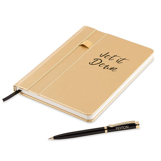 The Jot it Down Journal and Pen Set is a complete daily writing set that offers a bit of fun in the professional space. The shiny gold journal features the words "Jot it Down" to inspire more writing and comes with an elastic band on the front to hold the included ballpoint pen. Inside the journal is 64 lined pages of paper. Engrave the pen with a name, date, job role or company name. -Contents: Includes journal with 64-lined pages and pen -Size: 5.9" W x 8.06" H x 0.5" D -Material: Leatherette, Paper, Brass -Inspiration: A great graduation, new-job, promotion or congratulatory gift. Jot It Down Journal And Pen Set, In Gold, By Things Remembered.