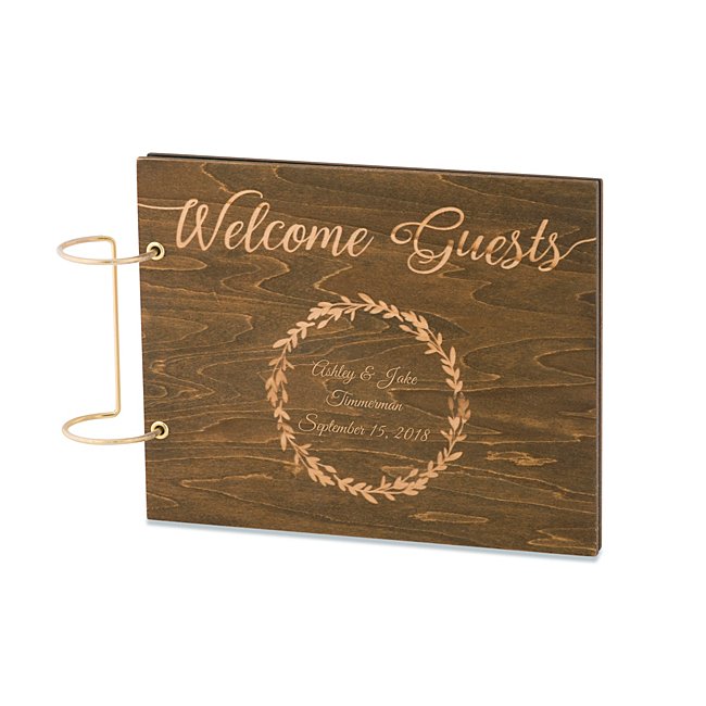 Complete their perfect day with well wishes from their favorite people thanks to this Rustic Wood Wedding Guestbook. The 41-page guestbook features a walnut-finished wood cover that reads, in gold script, "Welcome Guests" above a laurel design. Bold brass rings to the left complement the book and make it easy for friends and family to flip through all the messages. Engrave inside the laurel the couple's names, surname, wedding date or a sweet message. -Size: 8" W x 2.13" H x 1.61" D -Material: Wood -Inspiration: A great gift for an engagement party, bridal shower or bachelorette. Rustic Wood Wedding Guestbook, In Gold, By Things Remembered.